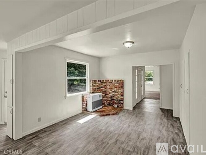 A room with a stone wall and wooden flooring is available for rent.