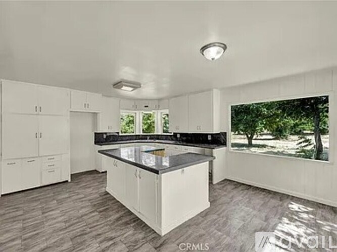 A spacious kitchen with white cabinets and a large island.