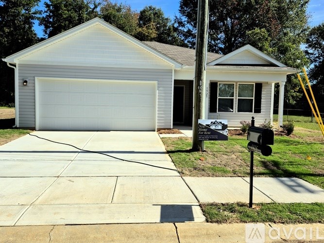 A small house with a garage and a mailbox in front.