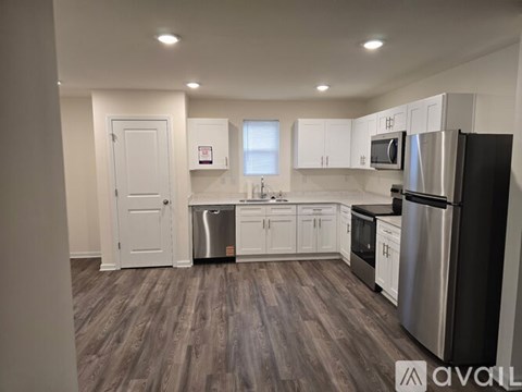 A modern kitchen with stainless steel appliances and white cabinets.