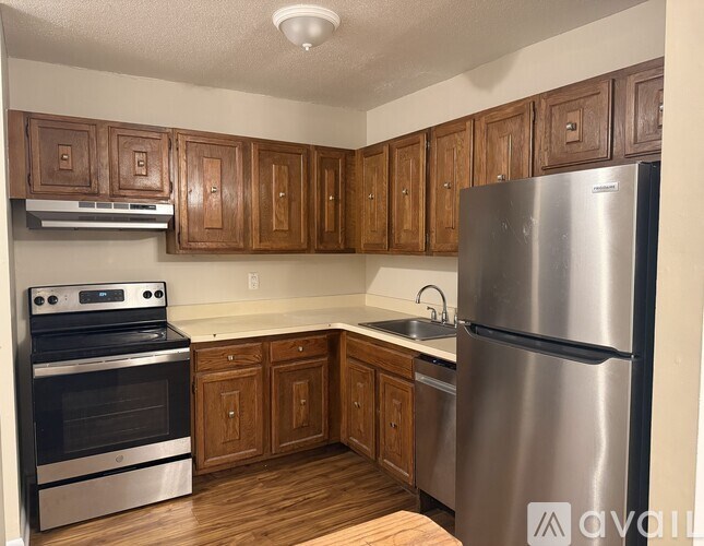 A kitchen with wooden cabinets and stainless steel appliances.