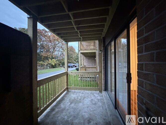 A balcony with a view of a tree and a house.