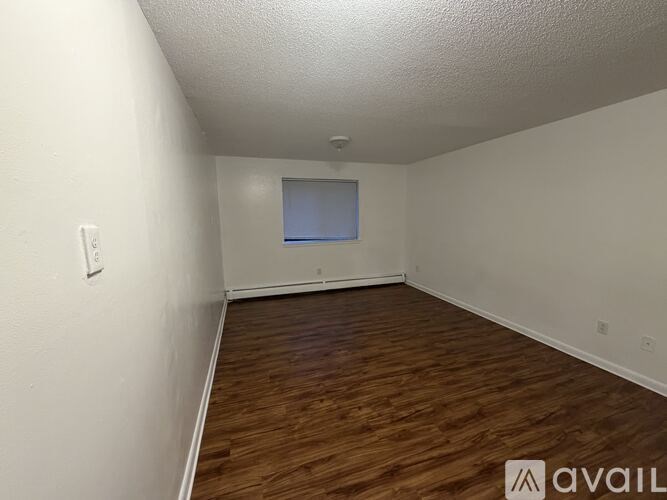 A room with wooden flooring and a window.