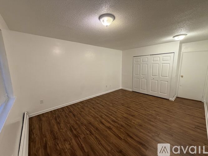 A room with wooden flooring and a white door.