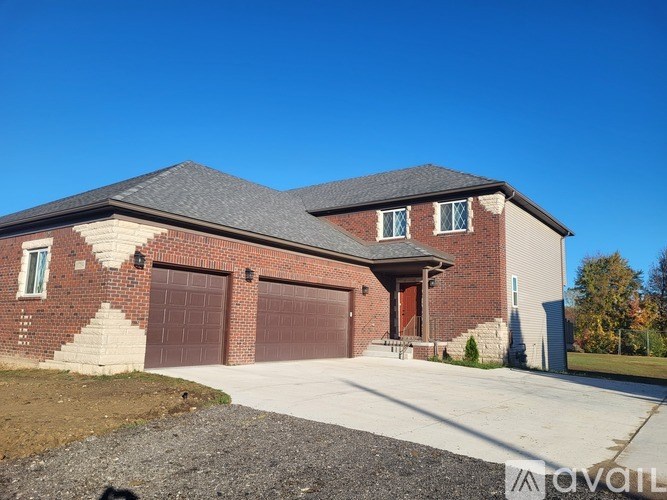 A two-story house with a garage door and a driveway.