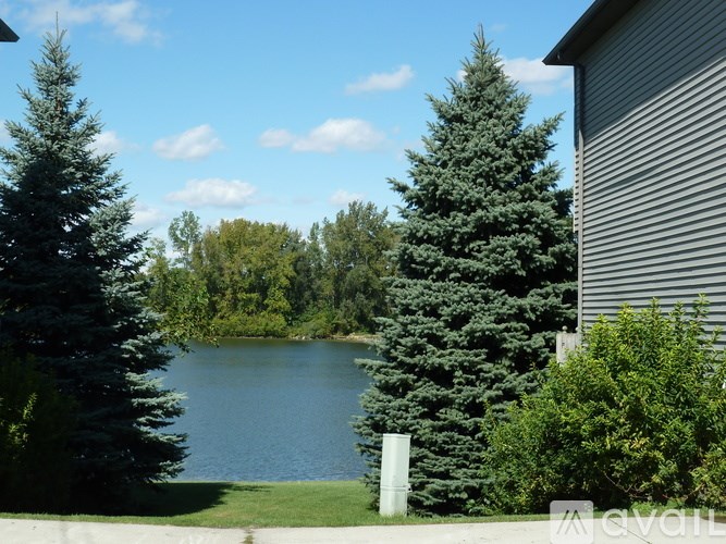 A lake surrounded by trees and a house.