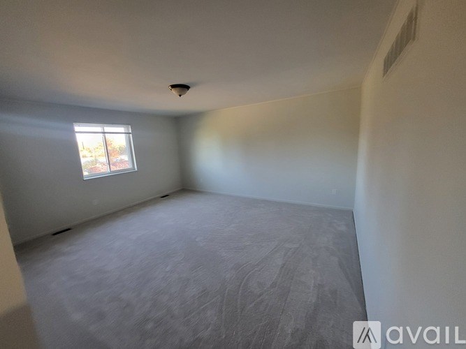 A room with a window and a ceiling fan.