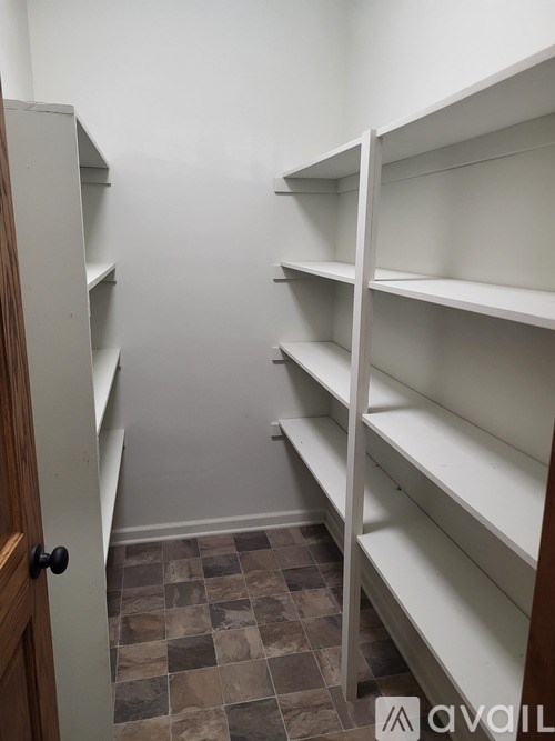 A room with a door and shelves.