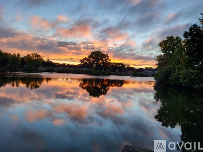 A serene lake reflects the vibrant colors of the sunset sky.