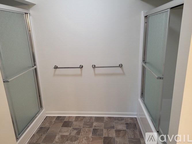 A bathroom with a tiled floor and two glass doors.