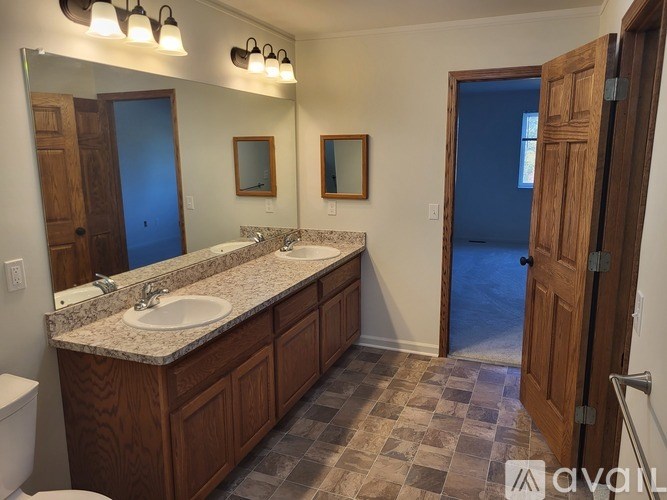 A bathroom with a sink, mirror, and toilet.