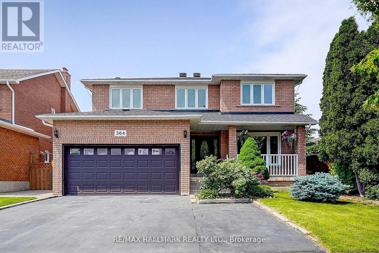 A house with a garage and a driveway in front of it.