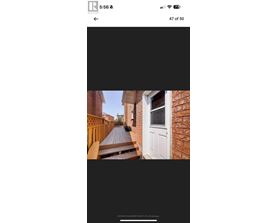 A white door is on the right side of a brick building.