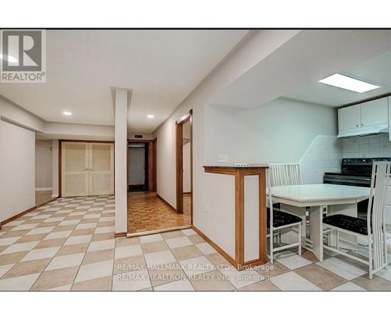 A kitchen area with a table and chairs is visible.