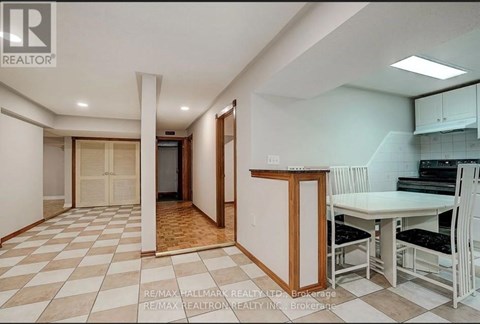 A kitchen area with a table and chairs is visible.