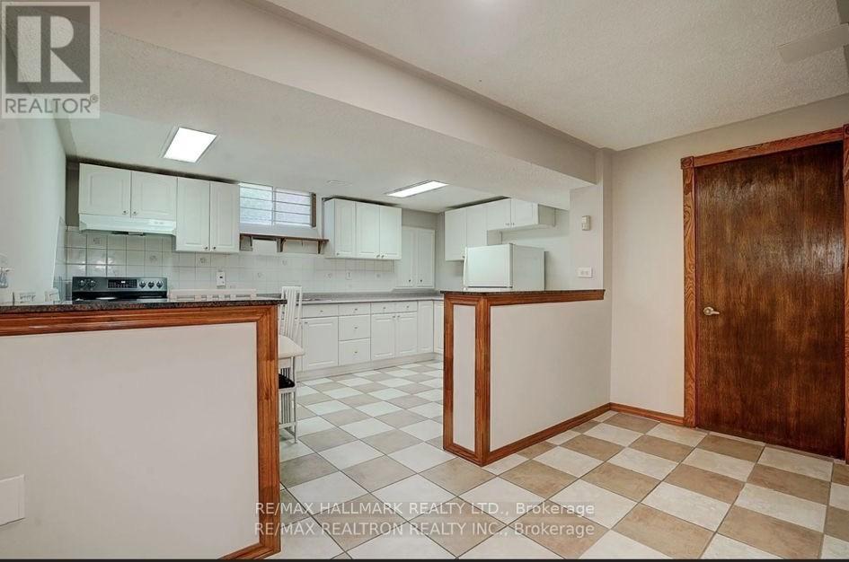 A kitchen with white cabinets and a checkered floor.