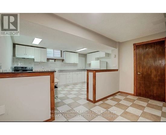 A kitchen with white cabinets and a checkered floor.