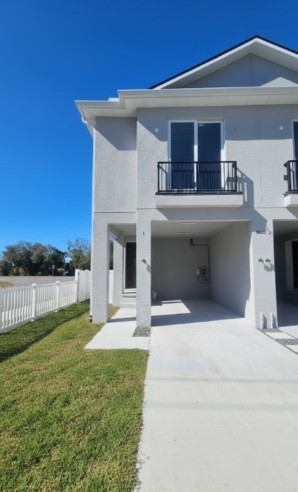 A white two-story house with a balcony on the second floor.