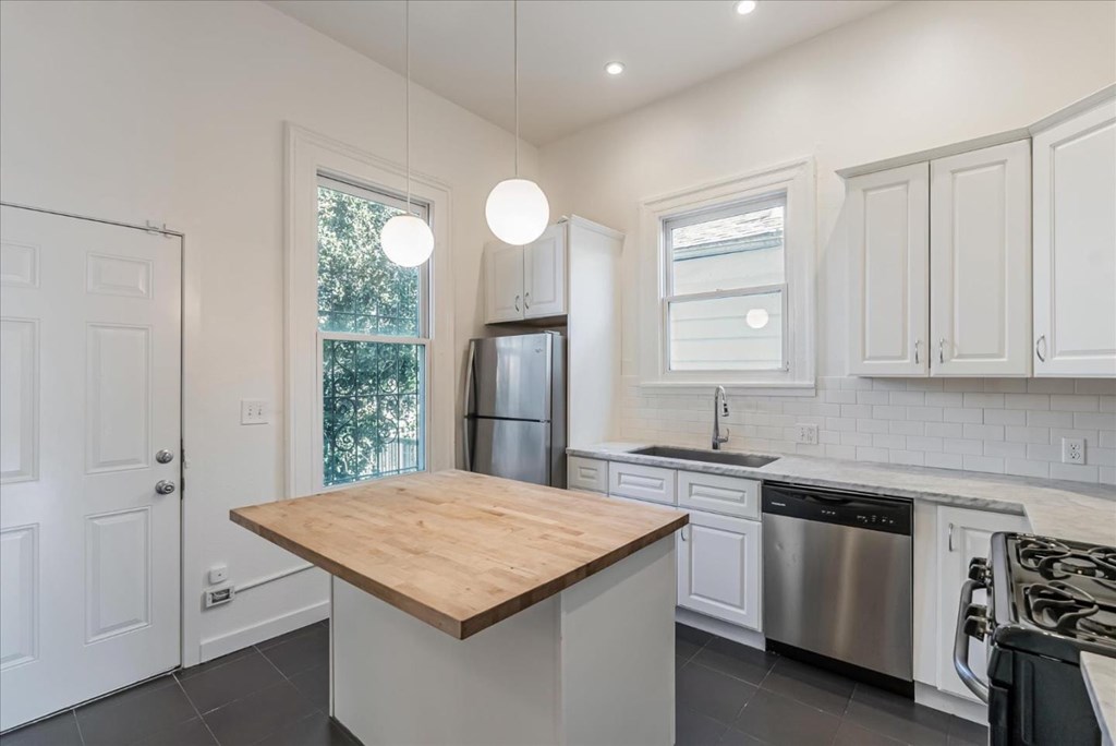 A kitchen with a wooden island in the middle of it.