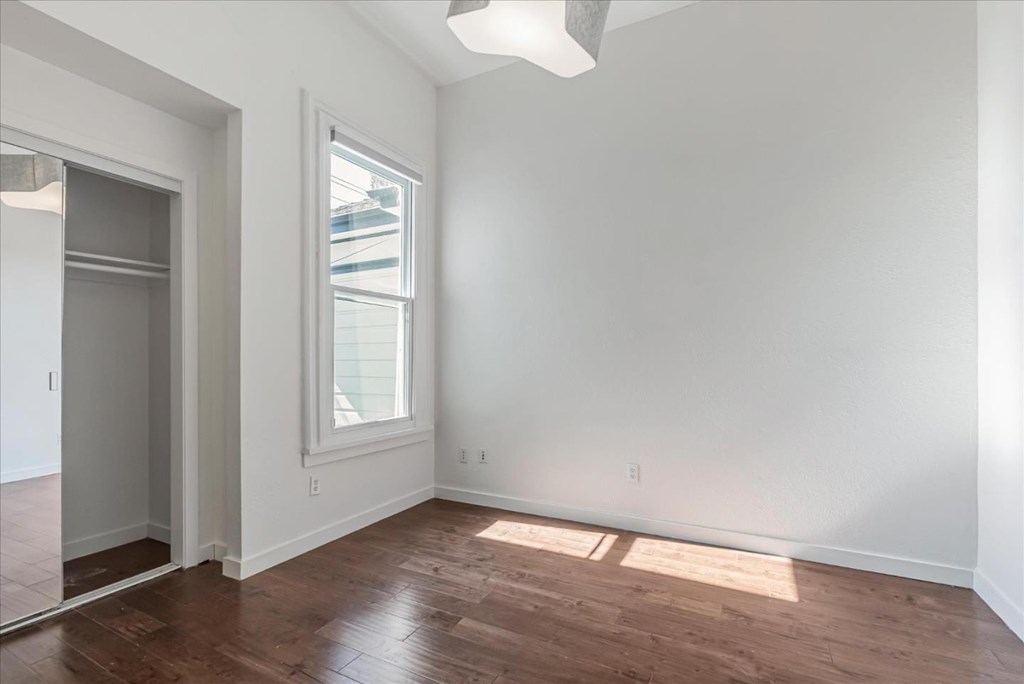 A room with a wooden floor and a window.