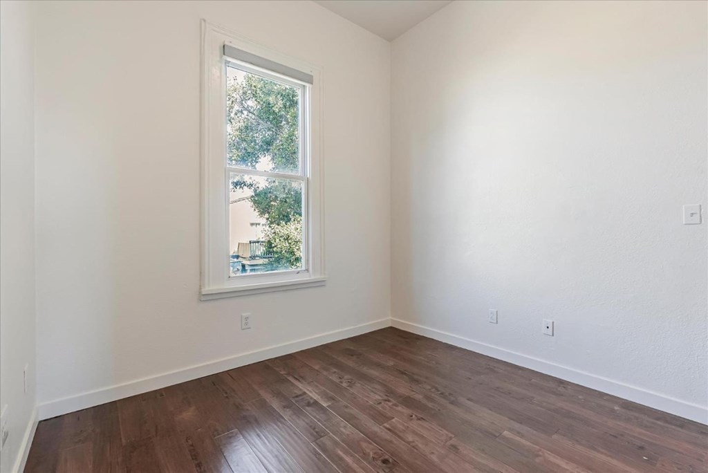 A room with a window and wooden flooring.