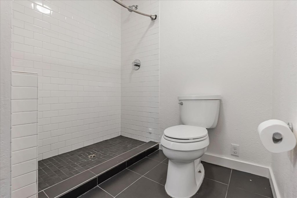 A white toilet in a bathroom with a walk-in shower.