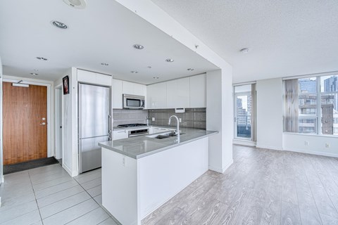 A modern kitchen with white cabinets and a large island.