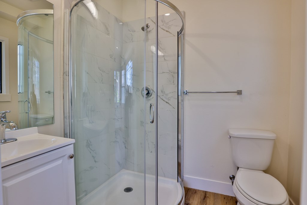 A white bathroom with a glass shower door.