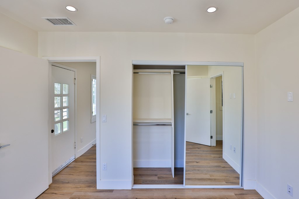 A room with a white wall and a wooden floor.