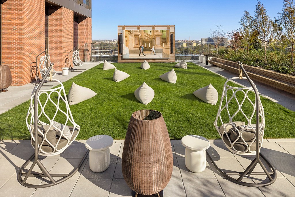 A patio with white chairs and a brown vase.