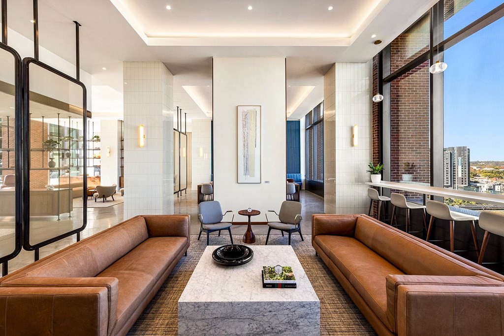 A modern living room with a large sectional sofa and a coffee table in the center.