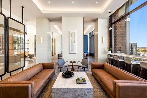 A modern living room with a large sectional sofa and a coffee table in the center.