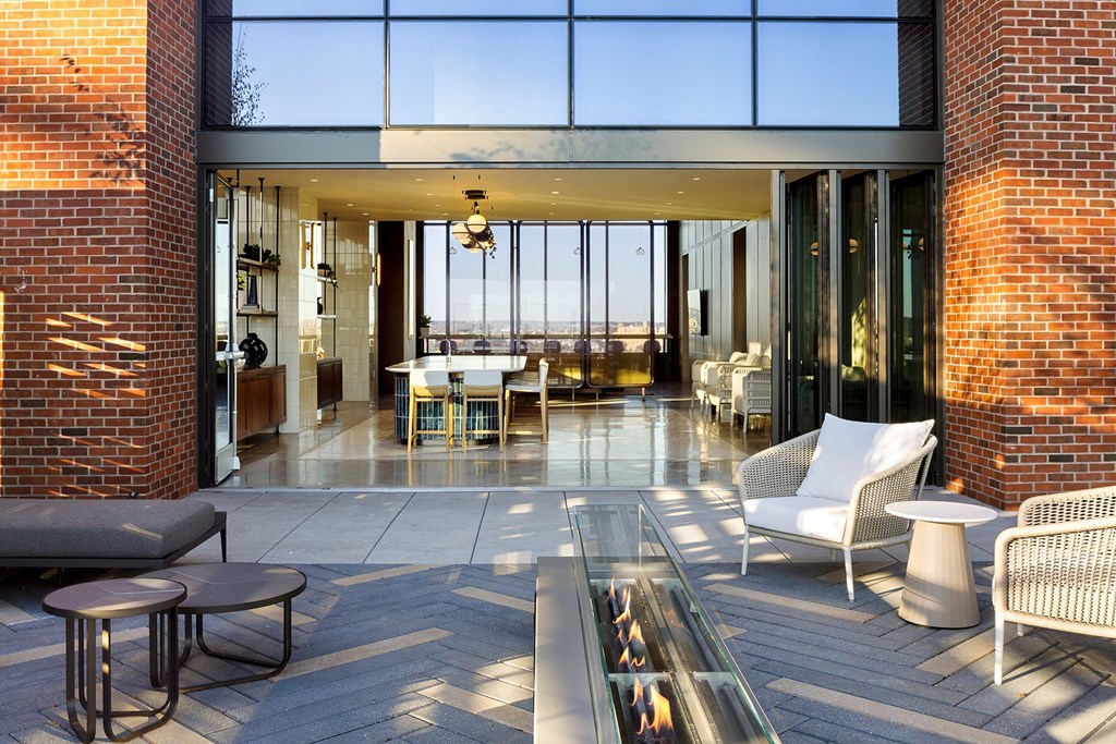 A modern patio with a fireplace and seating area.