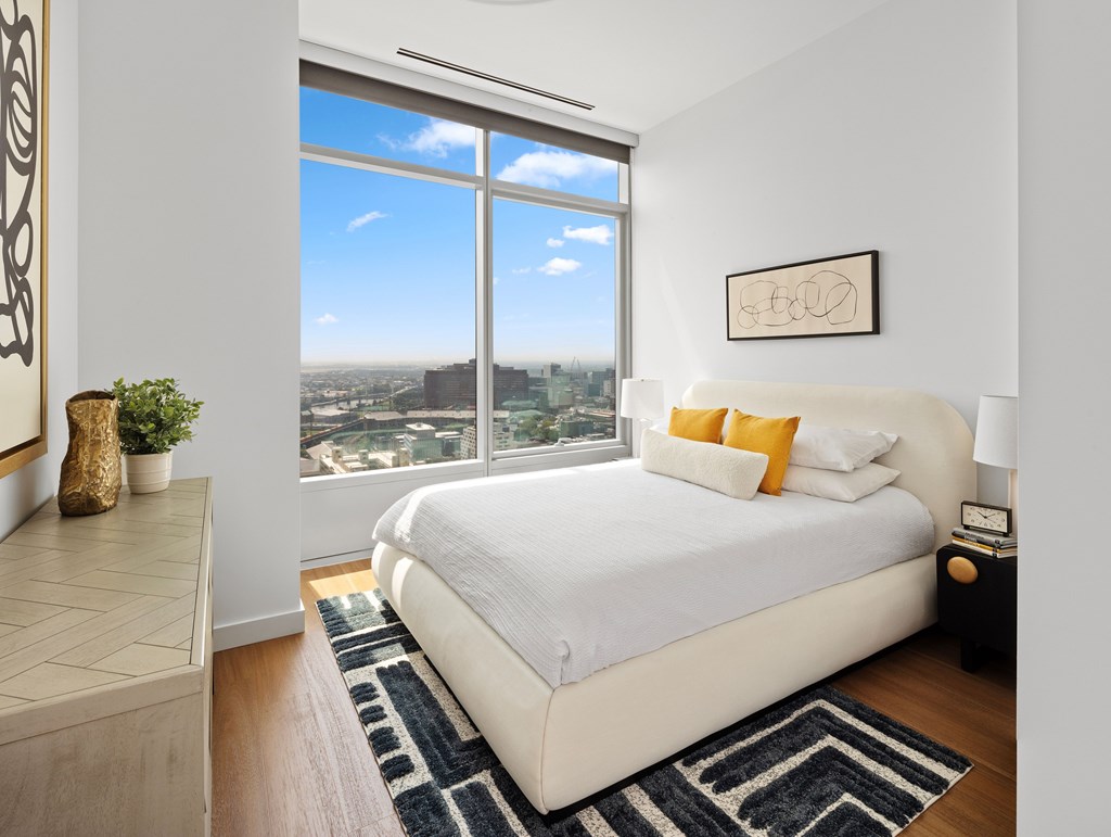 A bedroom with a large bed and a view of the city.
