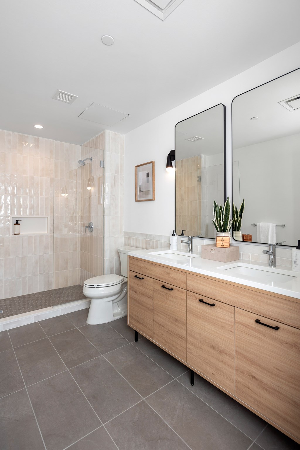 A modern bathroom with a toilet, a sink, and a mirror.