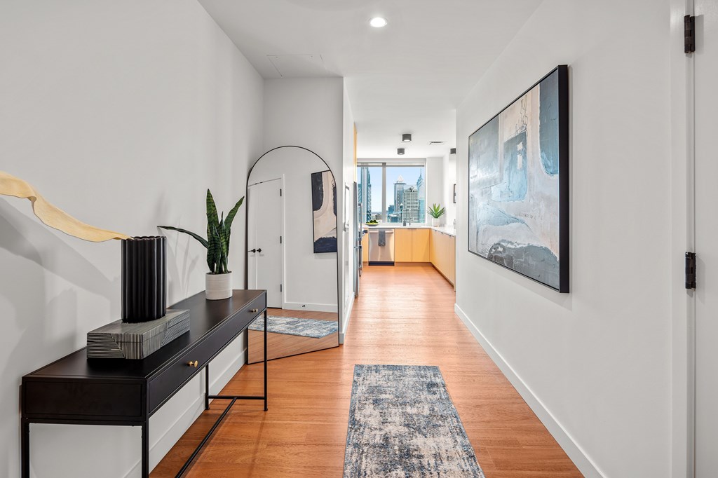 A hallway with a bench and a painting on the wall.