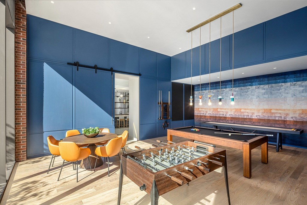A room with a blue wall and a foosball table.