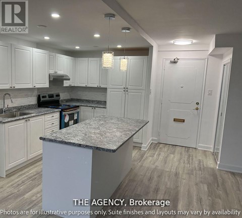A kitchen with white cabinets and a marble island.