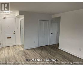 A white door with a brass handle is in a room with white walls and wood flooring.