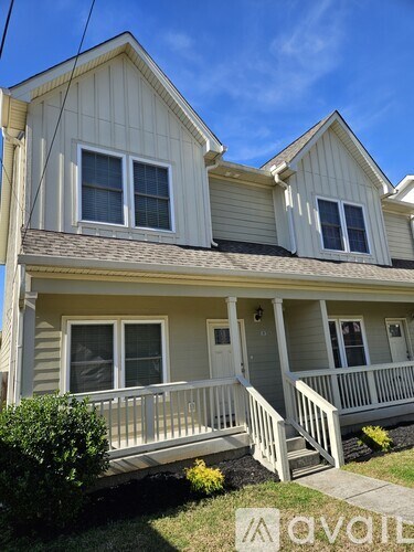 A two-story house with a front porch and a white door.