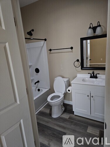 A bathroom with a toilet, sink, and mirror.