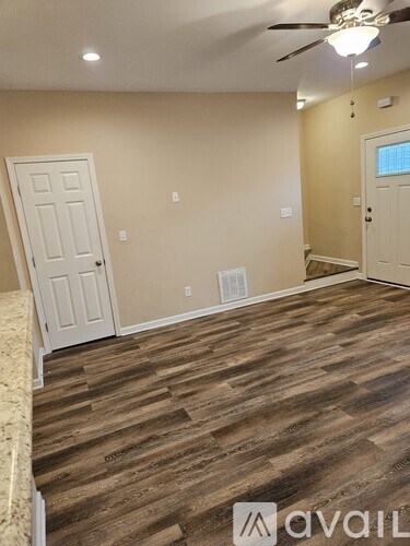 A room with wooden flooring and a ceiling fan.