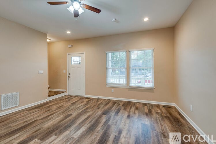 A room with a white door and a ceiling fan.