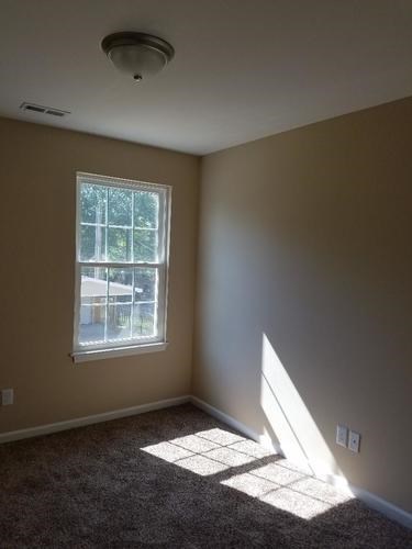 A room with a window and a ceiling light.