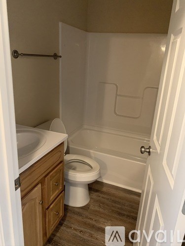 A bathroom with a toilet, sink, and a shower stall.