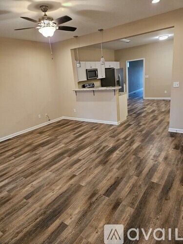 A room with wooden flooring and a ceiling fan.