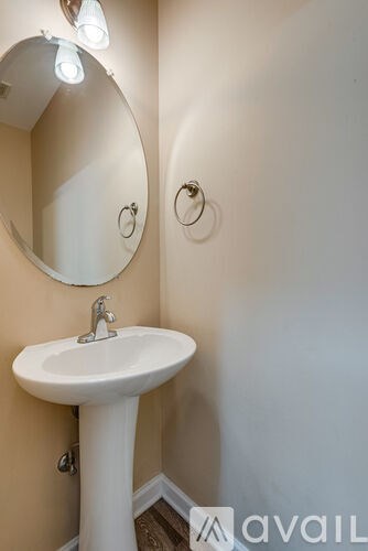 A room with wooden flooring and a mirror on the wall.