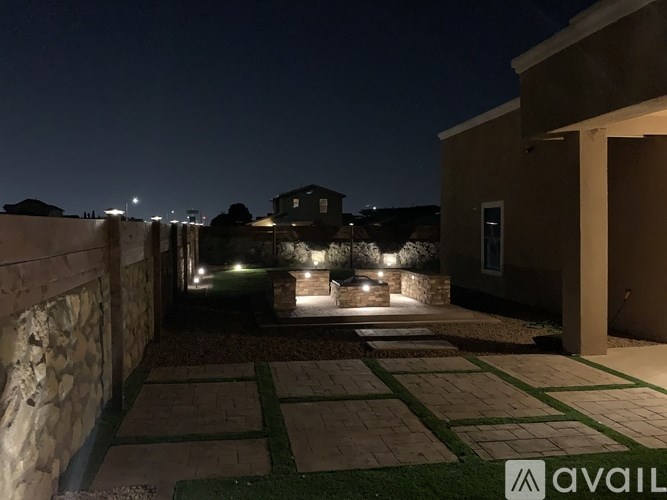 A patio area with stone flooring and lights on.
