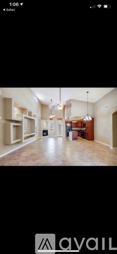 A room with a large open space and a kitchen area.
