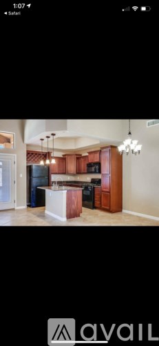 A kitchen with wooden cabinets and a white island.